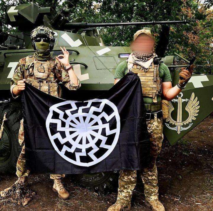 Grupo nazista na guerra da Ucrânia com bandeira do Sol Negro e gesto supremacista branco