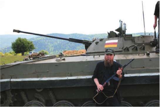 Dr. Aleksandr Dugin com uma Kalashnikov em frente a um tanque do exército insurgente da Ossétia do Sul. Junho de 2008, Ossétia do Sul