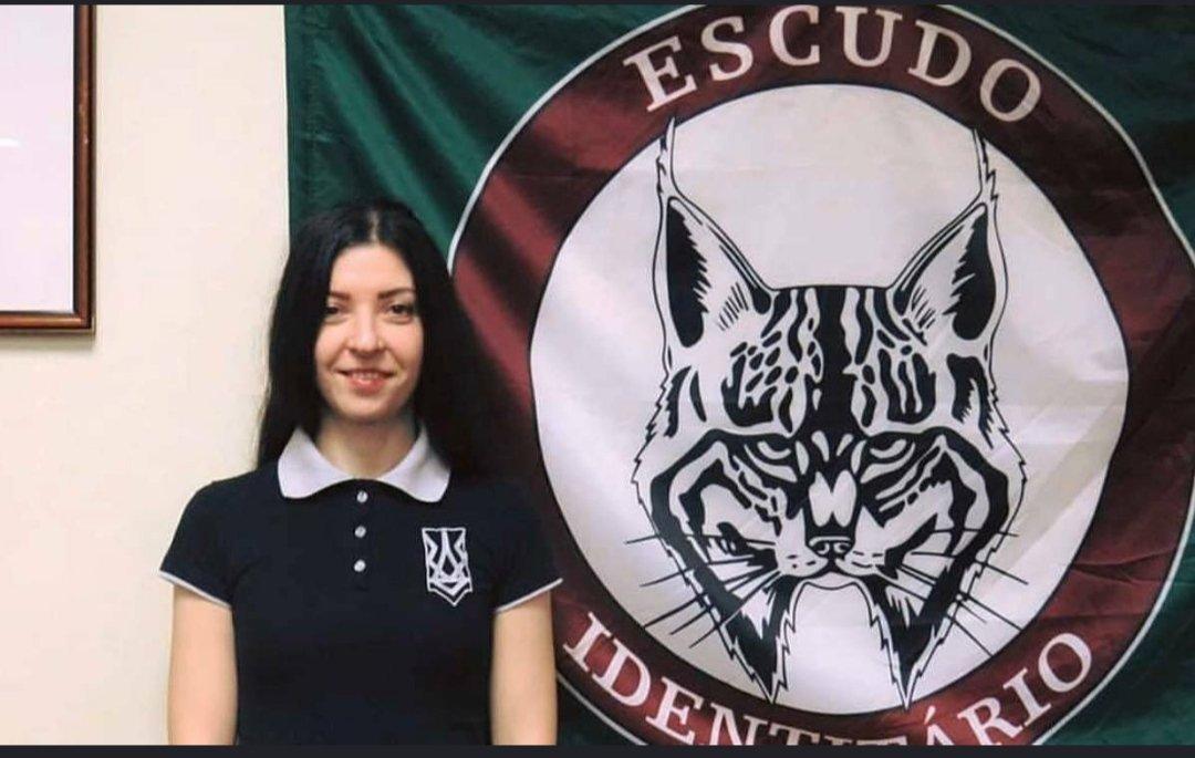 Olena Semenyaka com a bandeira do Escudo Identitário